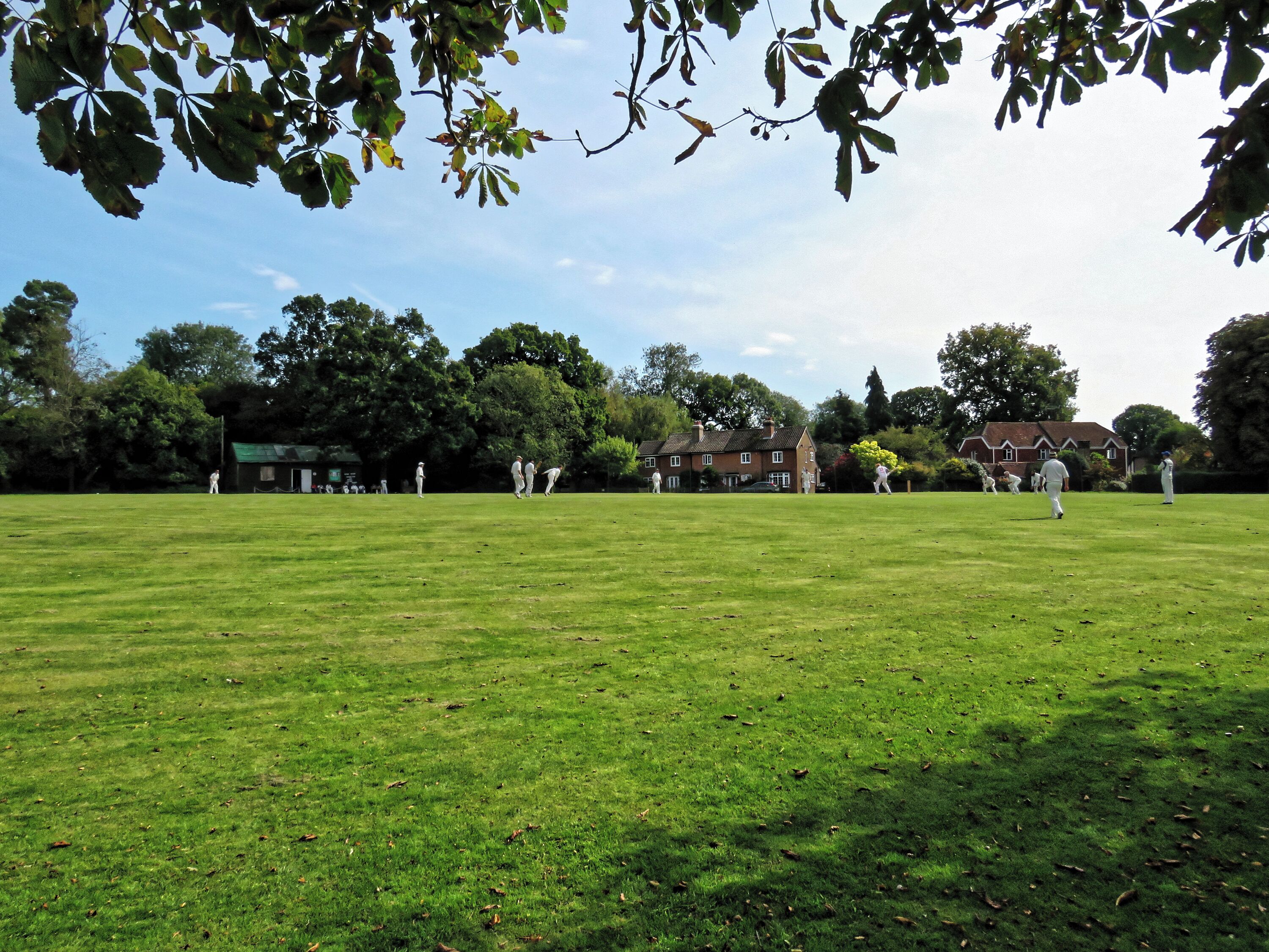 A public friendly Sunday cricket match between Nuthurst Cricket Club (which represents Nuthurst parish), and the East Dulwich, Middlesex-based Royal Challengers (batting) on the village green cricket ground at Mannings Heath in West Sussex, England. Camera: Canon PowerShot SX60 HS Software: File lens-corrected, optimized, perhaps cropped, with DxO OpticsPro 11 Elite, and likely further optimized with Adobe Photoshop CS2.