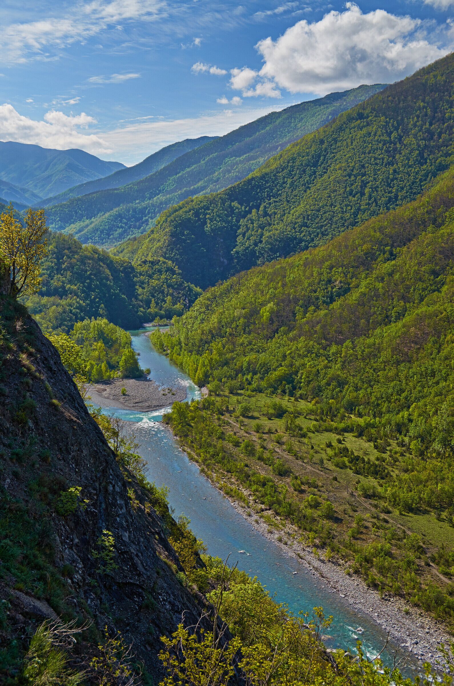 A river winding through a valley surrounded by lush green hills.