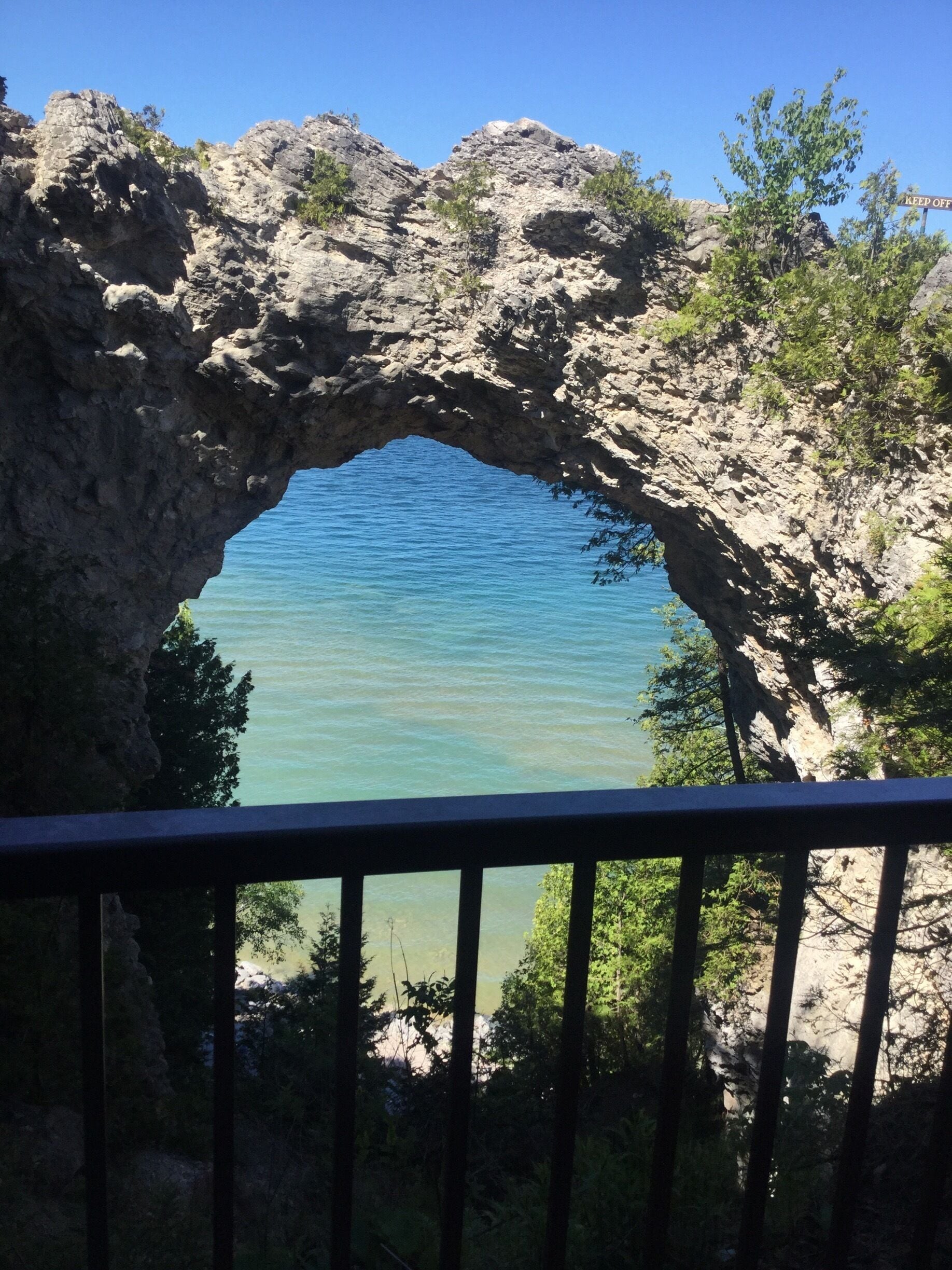 A natural rock arch over a body of water.