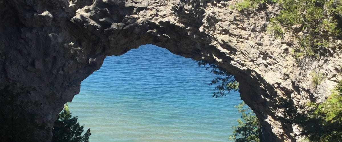 A natural rock arch over a body of water.