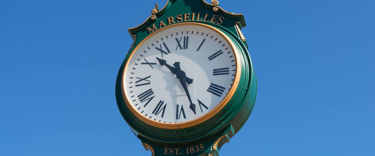 A clock with 'Marseilles' and 'EST. 1835' on its face.