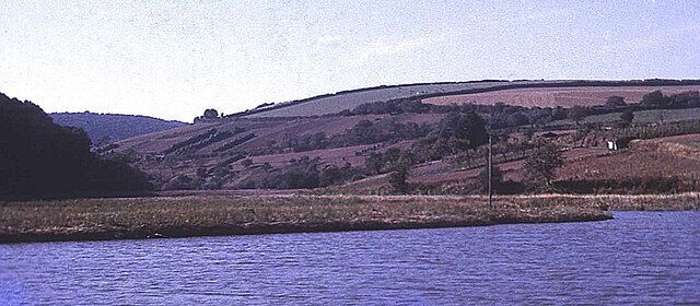 Tamar side valley to St Mellion View westwards from the river up the small side stream towards St Mellion. Typical of sunken estuaries, this very small stream has a relatively large valley, which is tidal for a mile from here. Strawberry Hill to the right and Hornifast Wood to the left. Ahead is some prime steep south-facing Tamar valley market gardening land - here still active in 1971, but today mostly reverted to scrub and farmland. This rural setting was not so tranquil in the war... http://www.bbc.co.uk/ww2peopleswar/stories/89/a5726289.shtml
