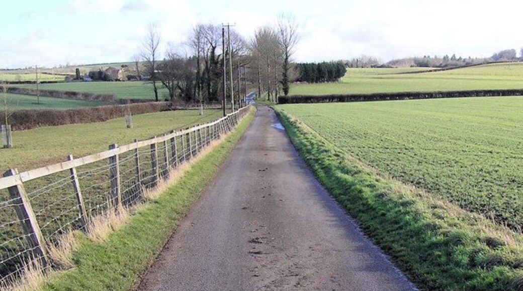 Footpath and drive to Wick Farm Just before the farm is a duck pond. Four footpaths merge at the farm.