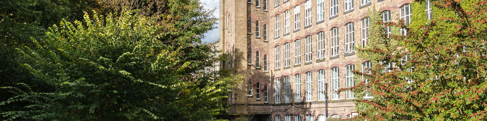 Clarence Mill - an old silk mill - on the banks of the Macclesfield Canal in Bollington Cheshire with moored narrow boats., Shutterstock ID 527879548, SF SSA Case with Manager Approval: Case 07151371,