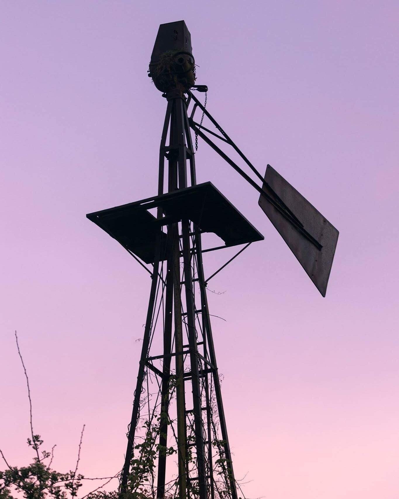 A windmill against a purple sky.