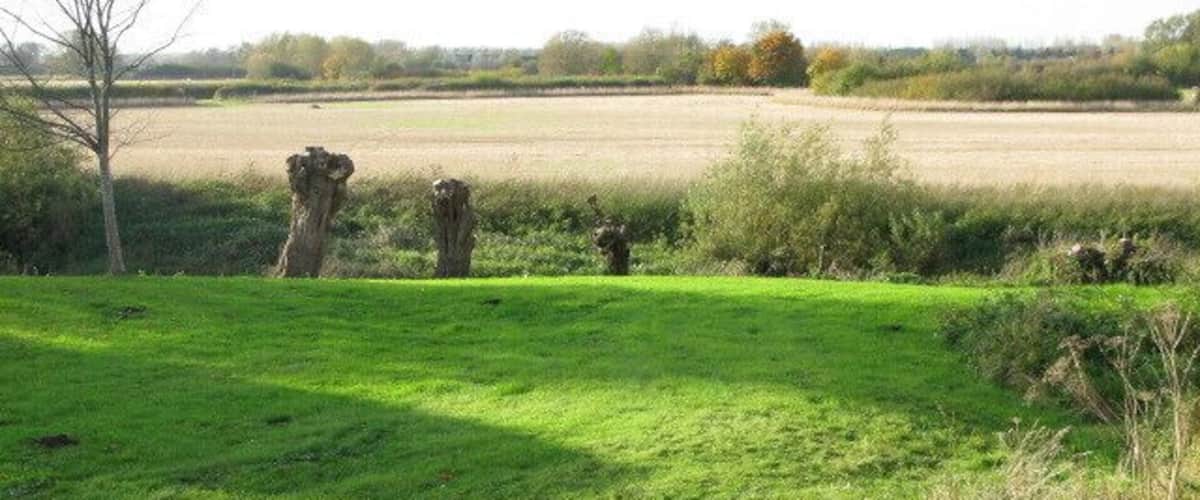 A grassy field with two large stone structures in the distance.
