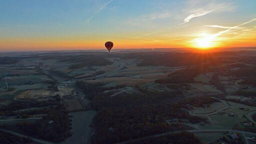 Taken from a second hot air balloon this shot shows a hot air balloon in the distance with a slight glow at sunrise. It is hard to stay calm when you are in a basket 4,000 feet up in the air.