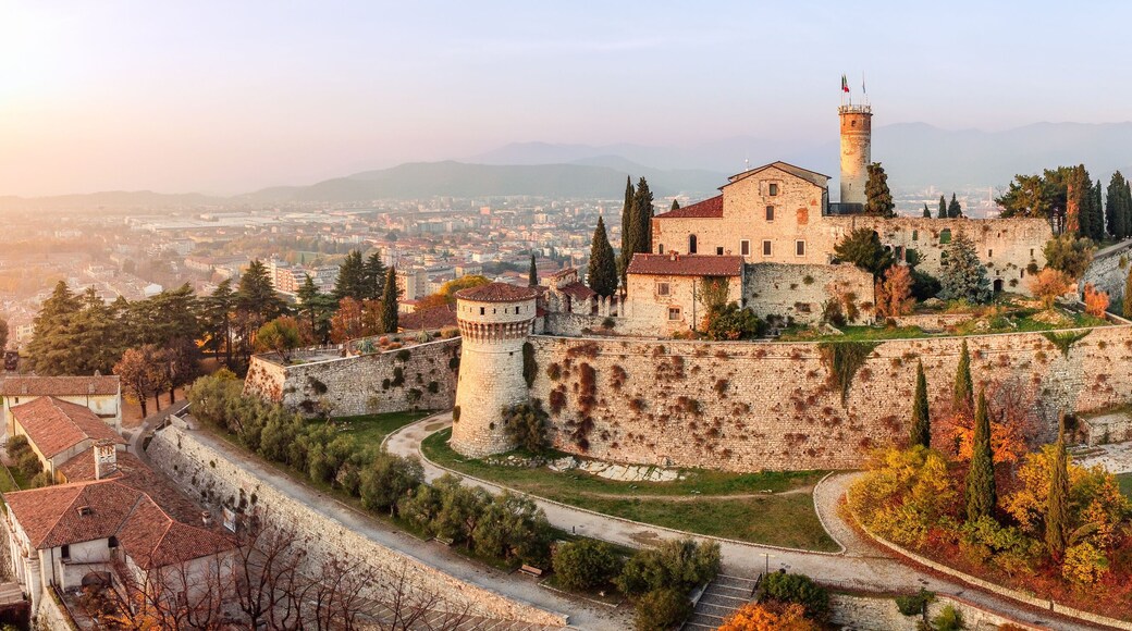 Panoramic drone view on medieval fortress Castello di Brescia, via del Castello and historical building complex on Cidneon mountain slope at autumn. Brescia, Lombardy, Northern Italy