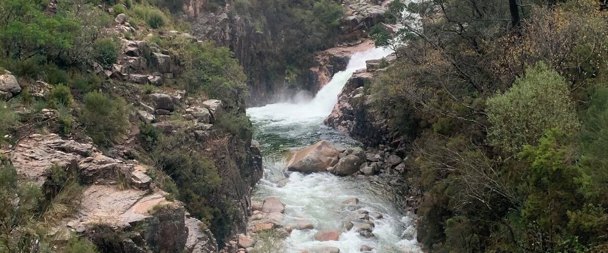 A river flowing through a rocky canyon with a waterfall.