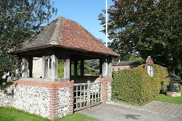 Church of England parish church of Saints Peter and Paul, Checkendon, Oxfordshire: lychgate. The gateway is also a war memorial: carved in the roof beams are the names of servicemen from the parish killed in the Second World War.