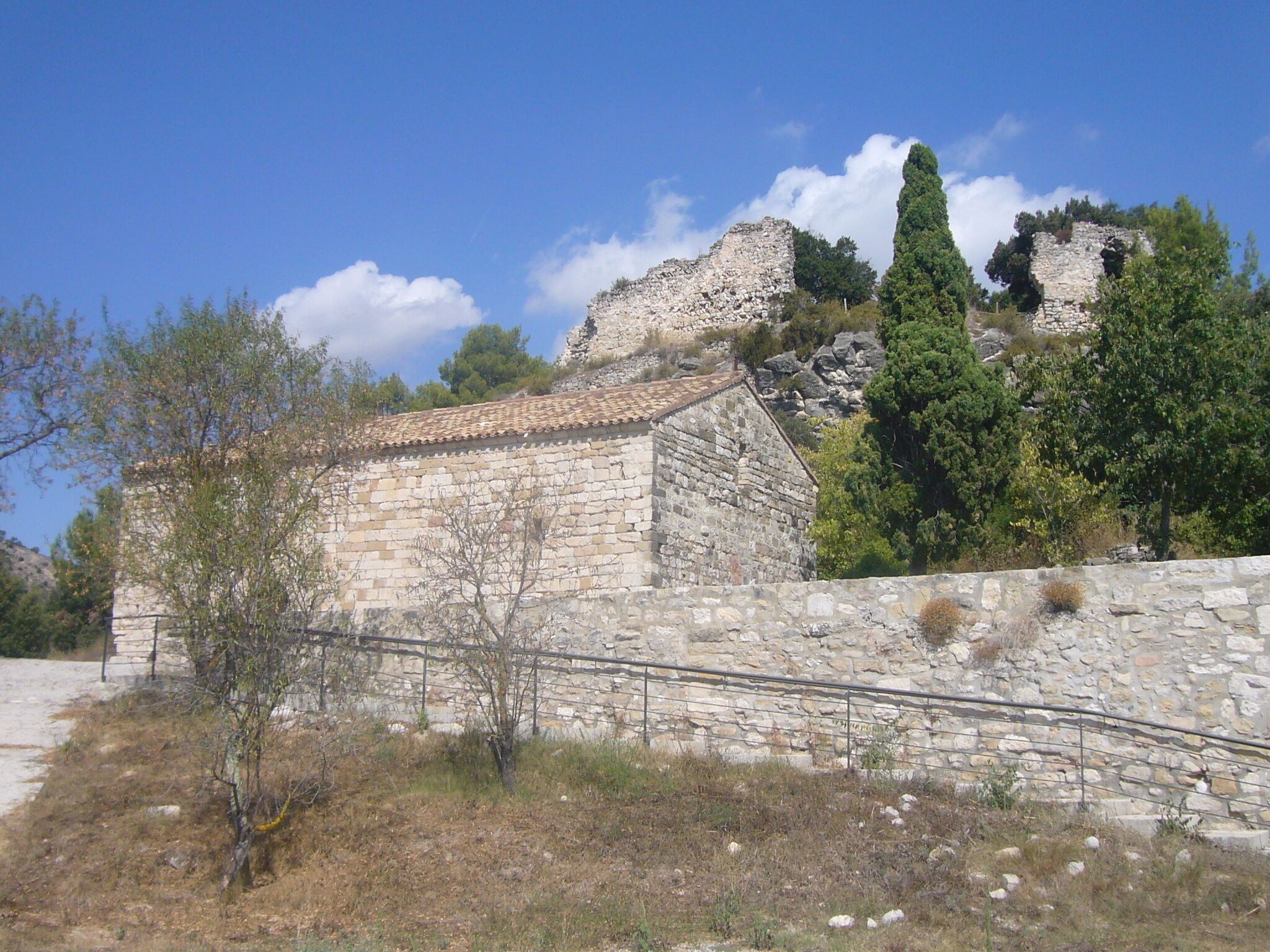 A l'esquerra, l'església romànica de Santa Maria del castell de Miralles. A dalt, restes del Castell de Miralles.