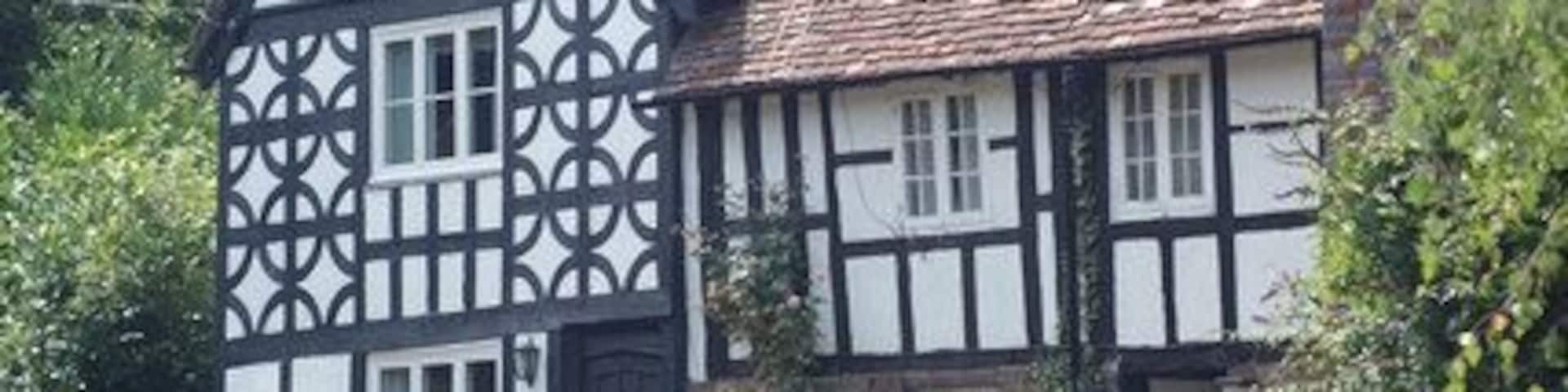 A Tudor-style half-timbered house with a sloped roof and a chimney.