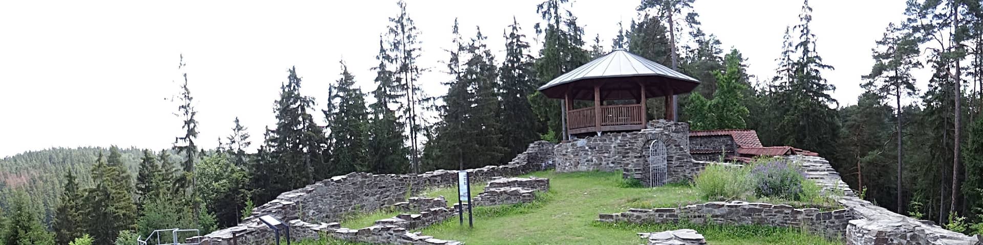 Ancient stone ruins with a wooden pavilion.