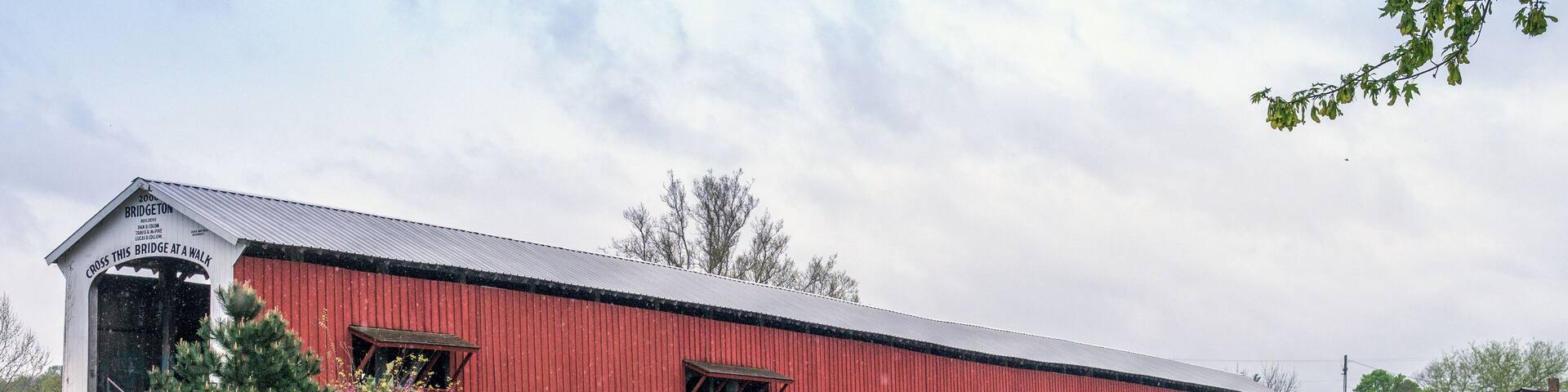 Old covered bridge over a roaring waterfall