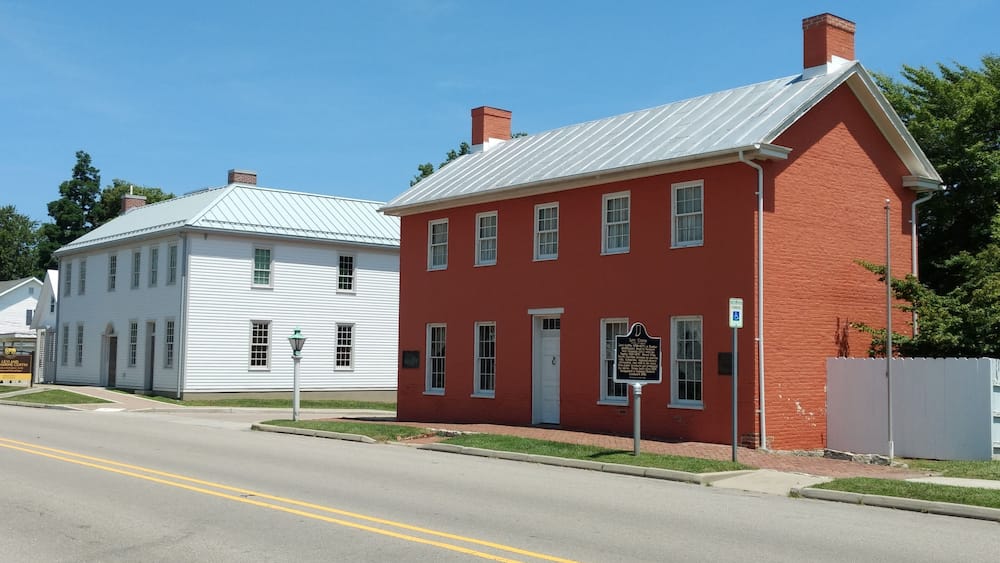 Un bâtiment historique de couleur rouge, avec un bâtiment blanc à côté.