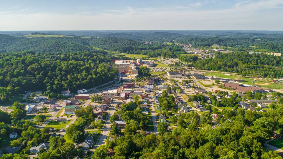 A town surrounded by lush green hills and forests.