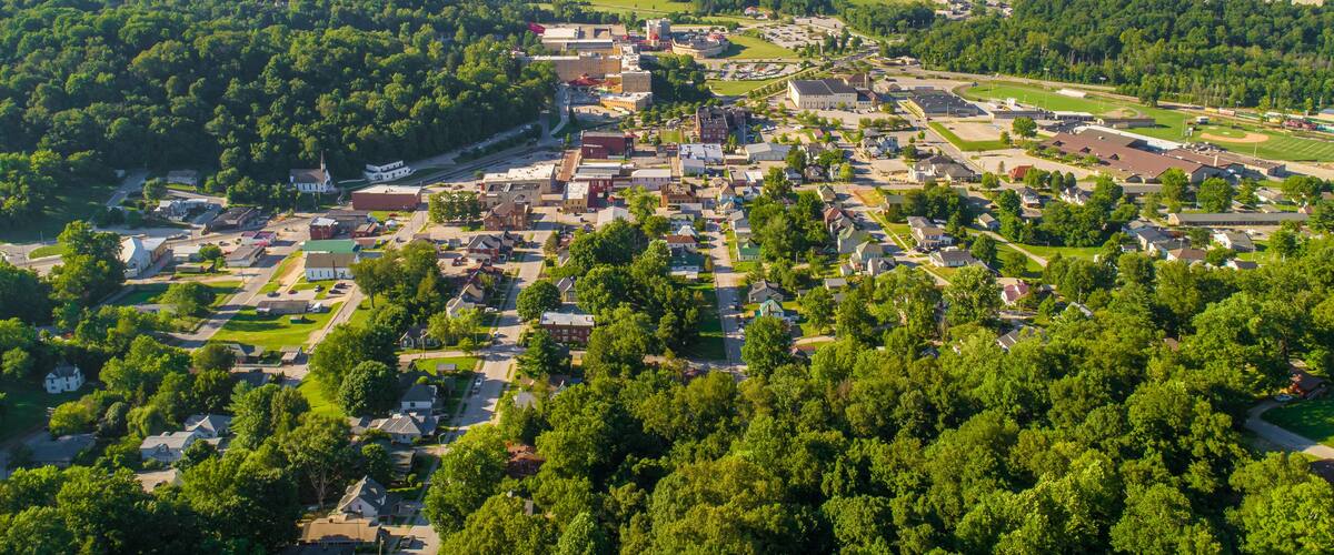A town surrounded by lush green hills and forests.