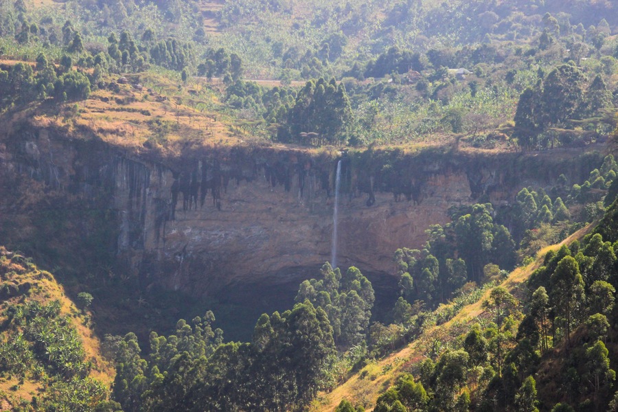Tall and thin Sipi Falls flowing among rocks in Uganda