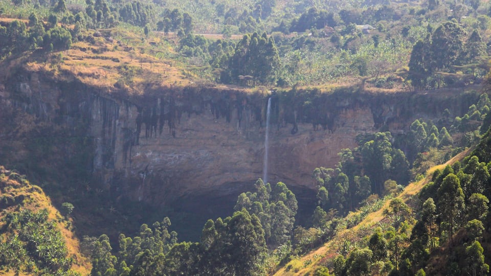 Tall and thin Sipi Falls flowing among rocks in Uganda