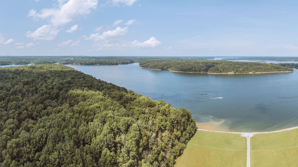 A lake surrounded by dense forests and a clear sky.