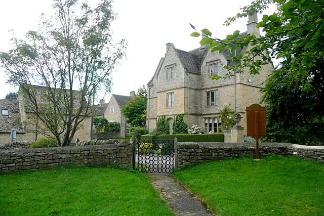 A stone house with a garden, a gate, and a mailbox.