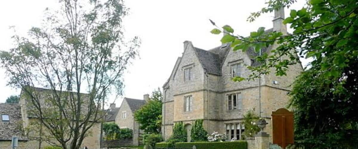 A stone house with a garden, a gate, and a mailbox.