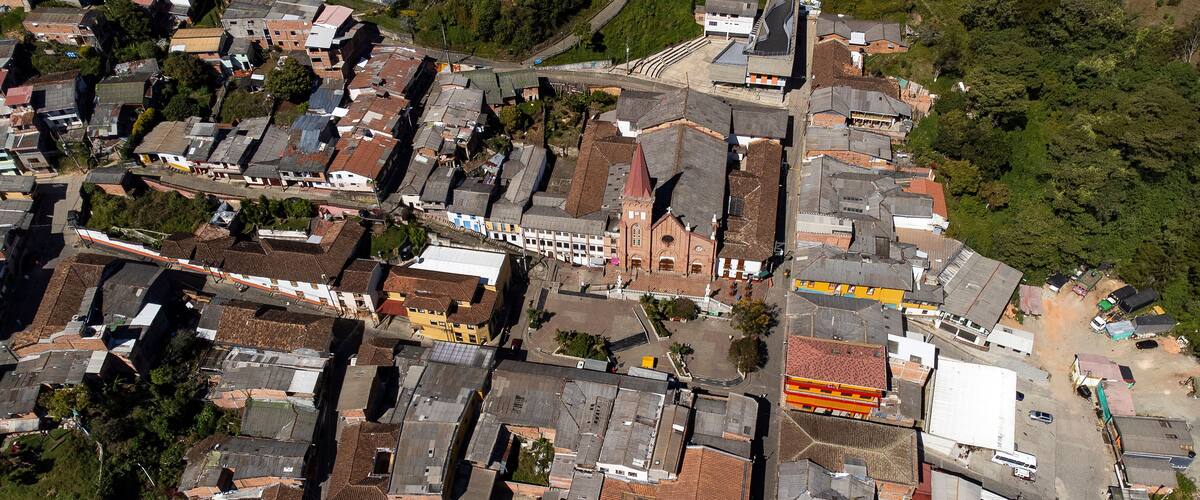An aerial view of a densely packed urban area with various buildings, roads, and a church.