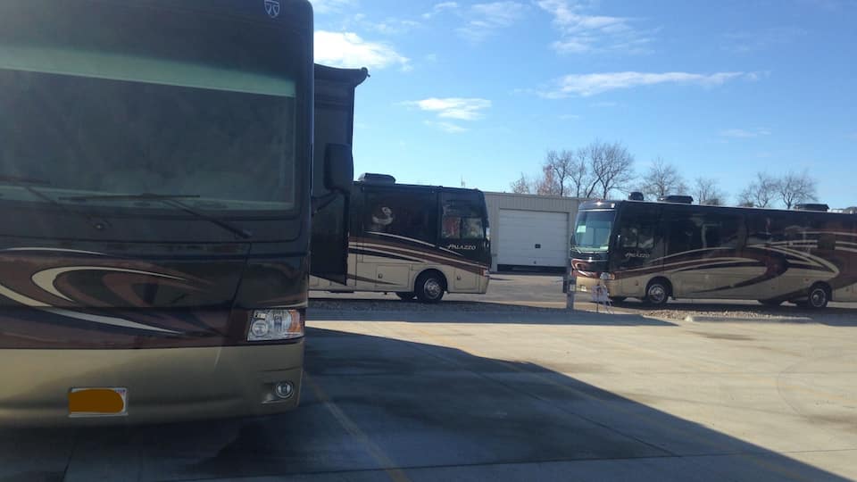A parking lot with several RVs and buses.