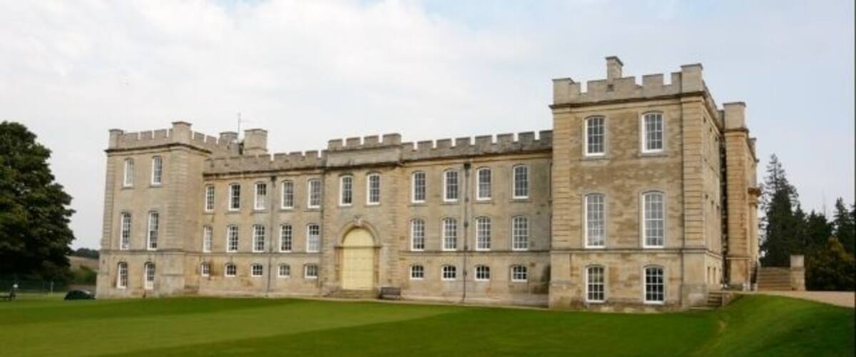 A large, historic stone building with multiple windows and a central entrance.