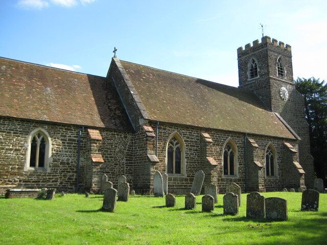 A church with a clock tower and a graveyard.