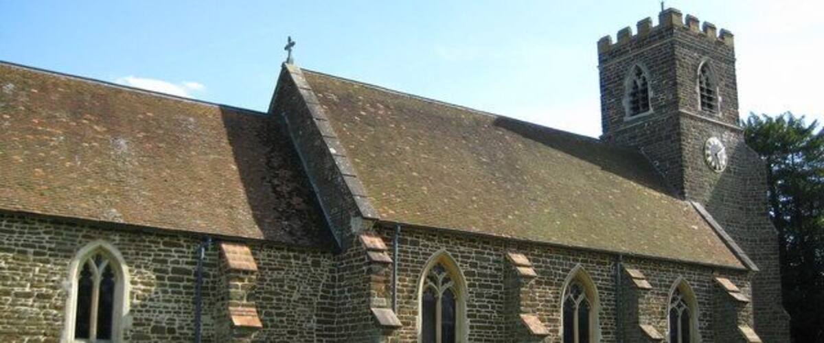 A church with a clock tower and a graveyard.