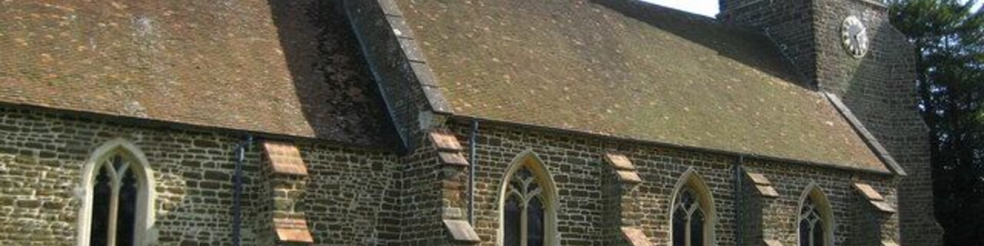 A church with a clock tower and a graveyard.