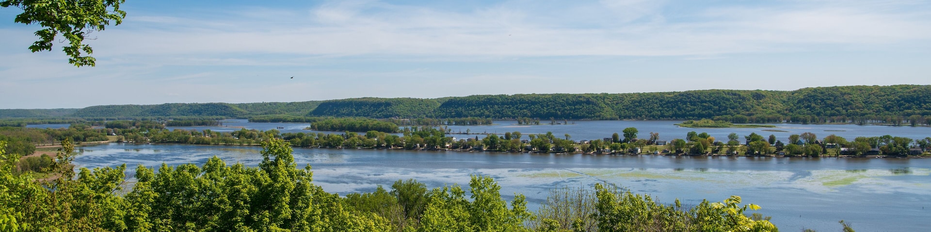 A river surrounded by dense green forest and hills.