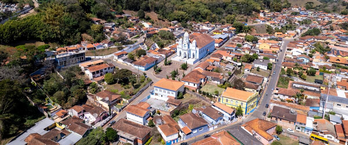 A town with a prominent church, surrounded by residential buildings and hills.