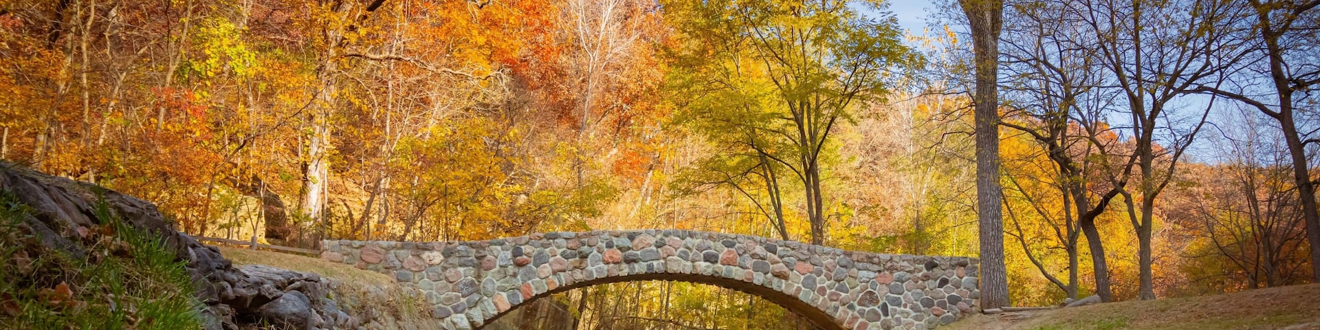Pedestrian rock bridge over Peas Creek in Ledges State Park, Iowa, during fall