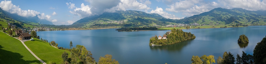 A lake surrounded by mountains, a small island, and a village.