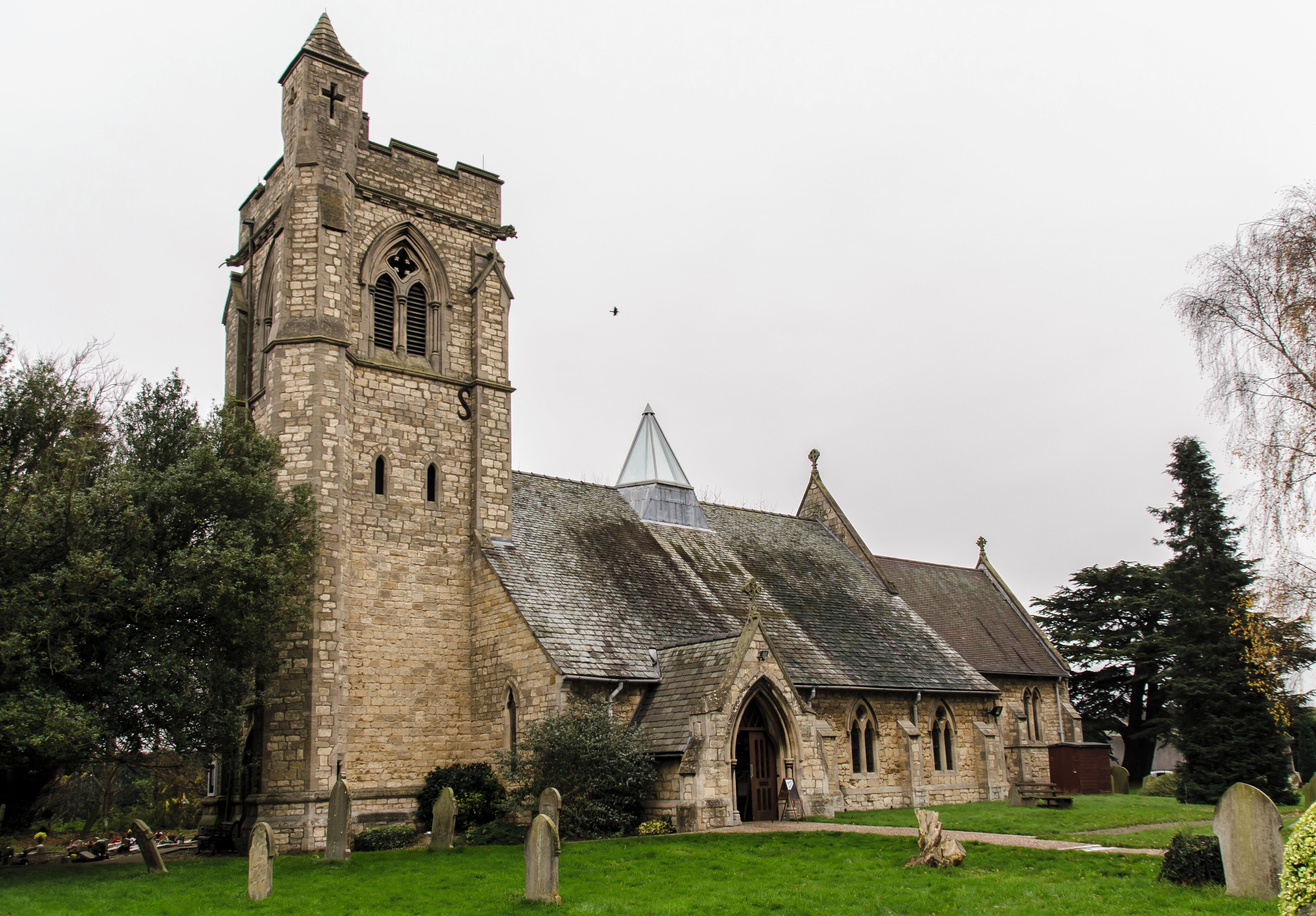A historic stone church with a tall tower and pointed arch windows.