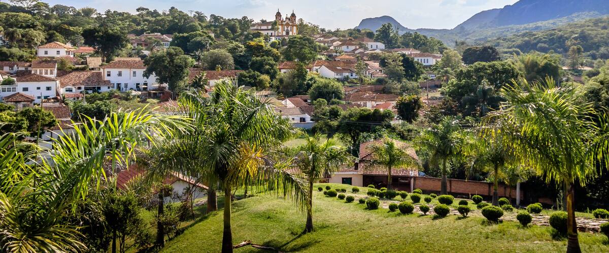 A hillside town with white houses, a church, and lush greenery.