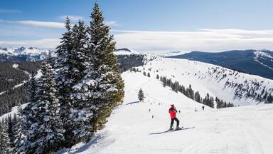 Female skier on slope looking out at Rocky Mountains
