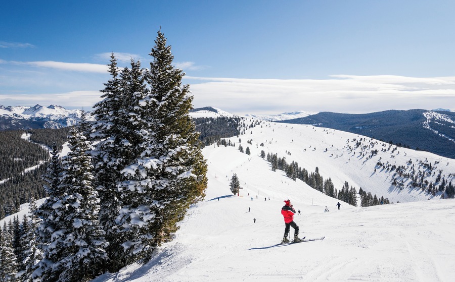 Female skier on slope looking out at Rocky Mountains