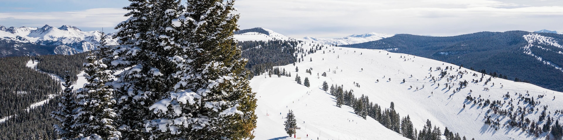Female skier on slope looking out at Rocky Mountains