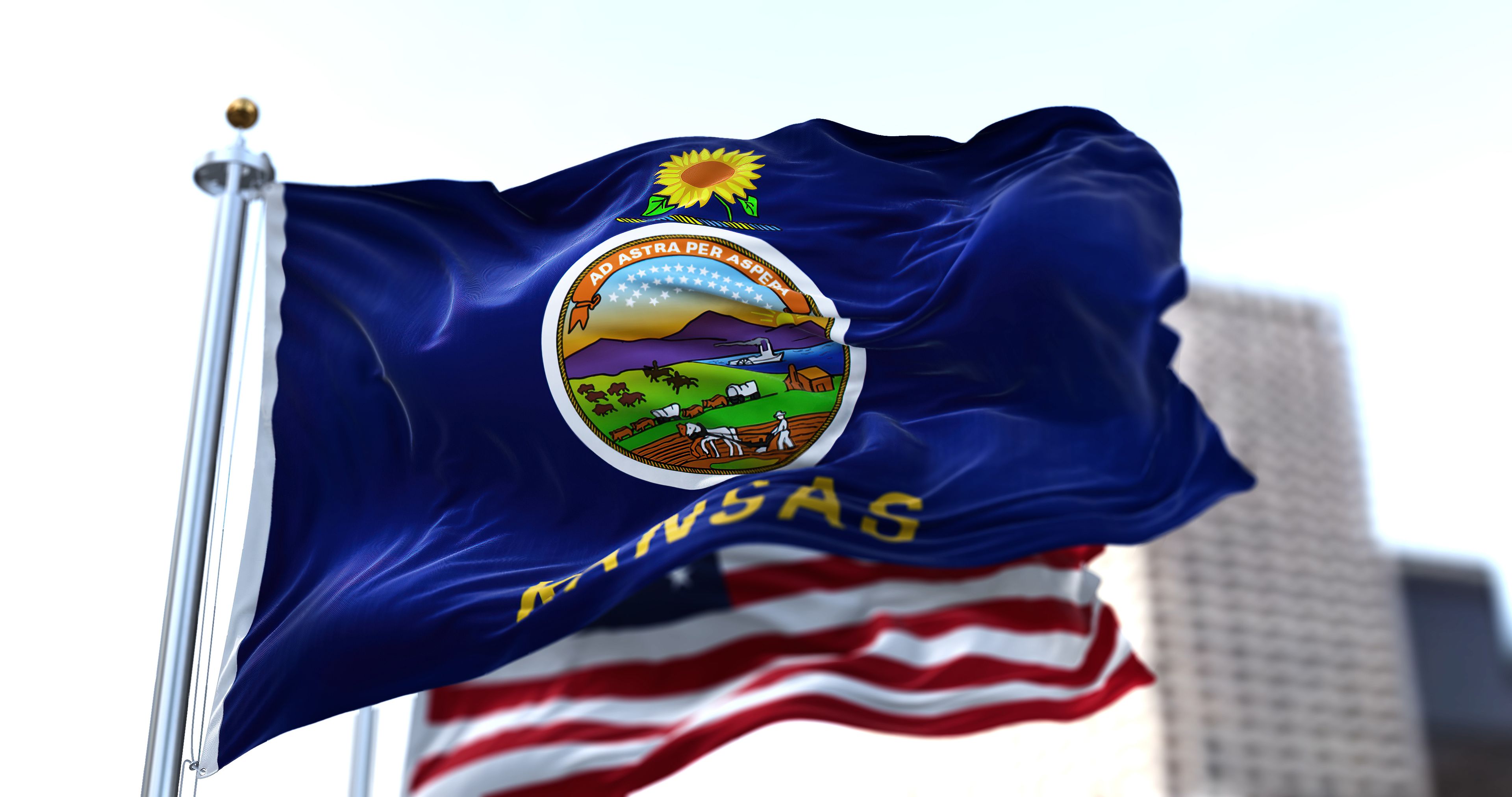 the flag of the US state of Kansas waving in the wind with the American flag blurred in the background