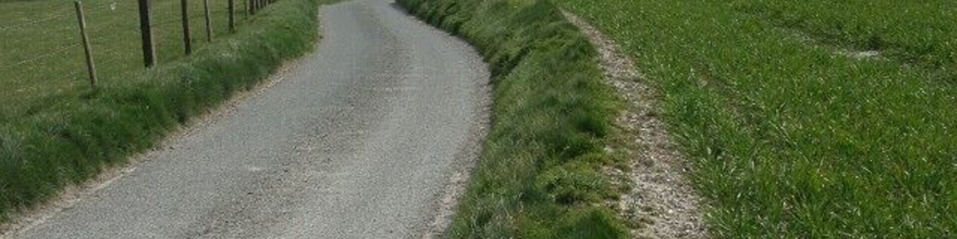 Lane and farmland, Enford Zigzagging stretch of the lane leading to Enford Farm.