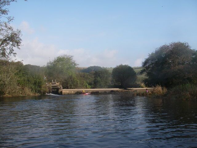 Aveton Gifford Weir The weir at the tidal limit of the Avon estuary near Aveton Gifford. The river control hatch is visible on the left, but less visible from this viewpoint is the unusual salmon pass. It runs parallel to the weir face in the centre of the weir.