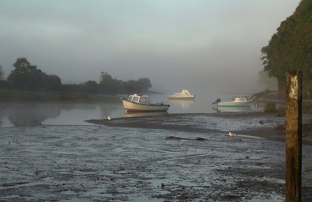 Boats on the Avon Morning mist hangs over the upper Avon estuary. The tidal mudflats are crossed by a stream from the Ashford valley joining the Avon from the north (right).