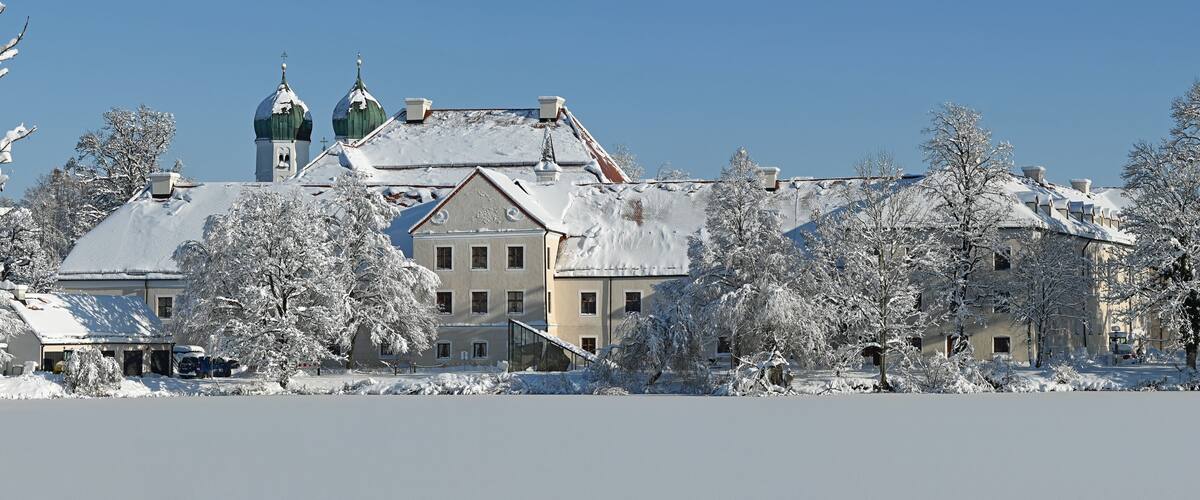 A snow-covered building with a green dome and multiple chimneys.