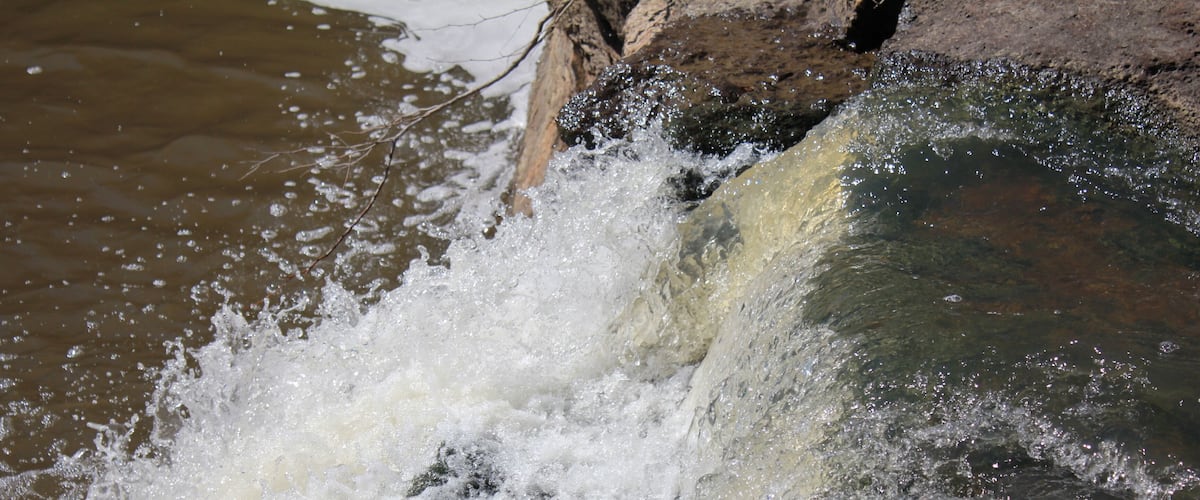 A waterfall cascading over rocks into a pool of water.