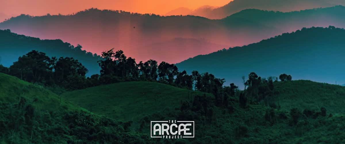 A landscape with rolling hills and a sunset sky.