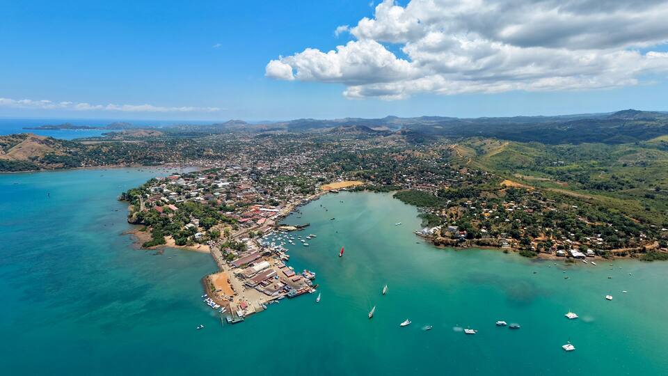 A coastal town with a bay, boats, and surrounding hills.