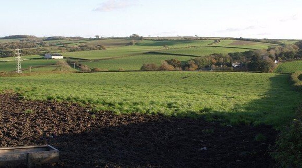 Stonyland from the north. Partly hidden by the slope of the field, the buildings in the valley at Stonyland are close to the bridge shown in 601142. Beyond, the lane to Charlacott Cross climbs round a bend (the point where 599127 and other photos were taken), past a barn and a small tree (see 601121).